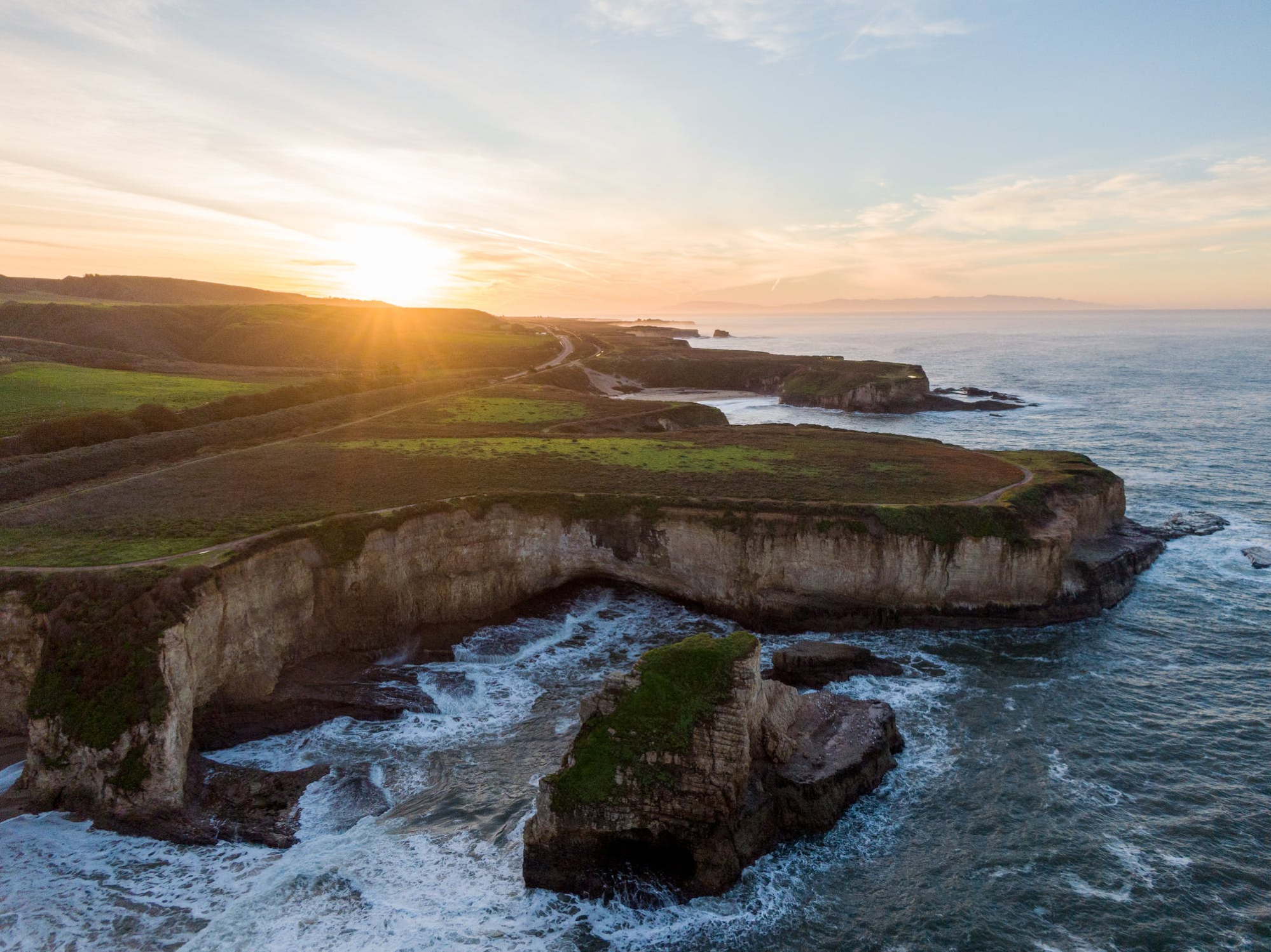 This is an image of a cliffside by the ocean at sunset.