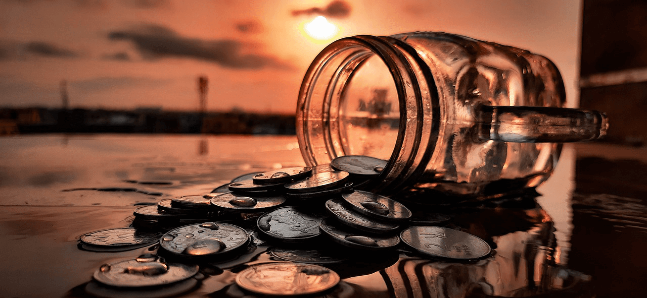 A jar of coins poured on the floor in the sunset