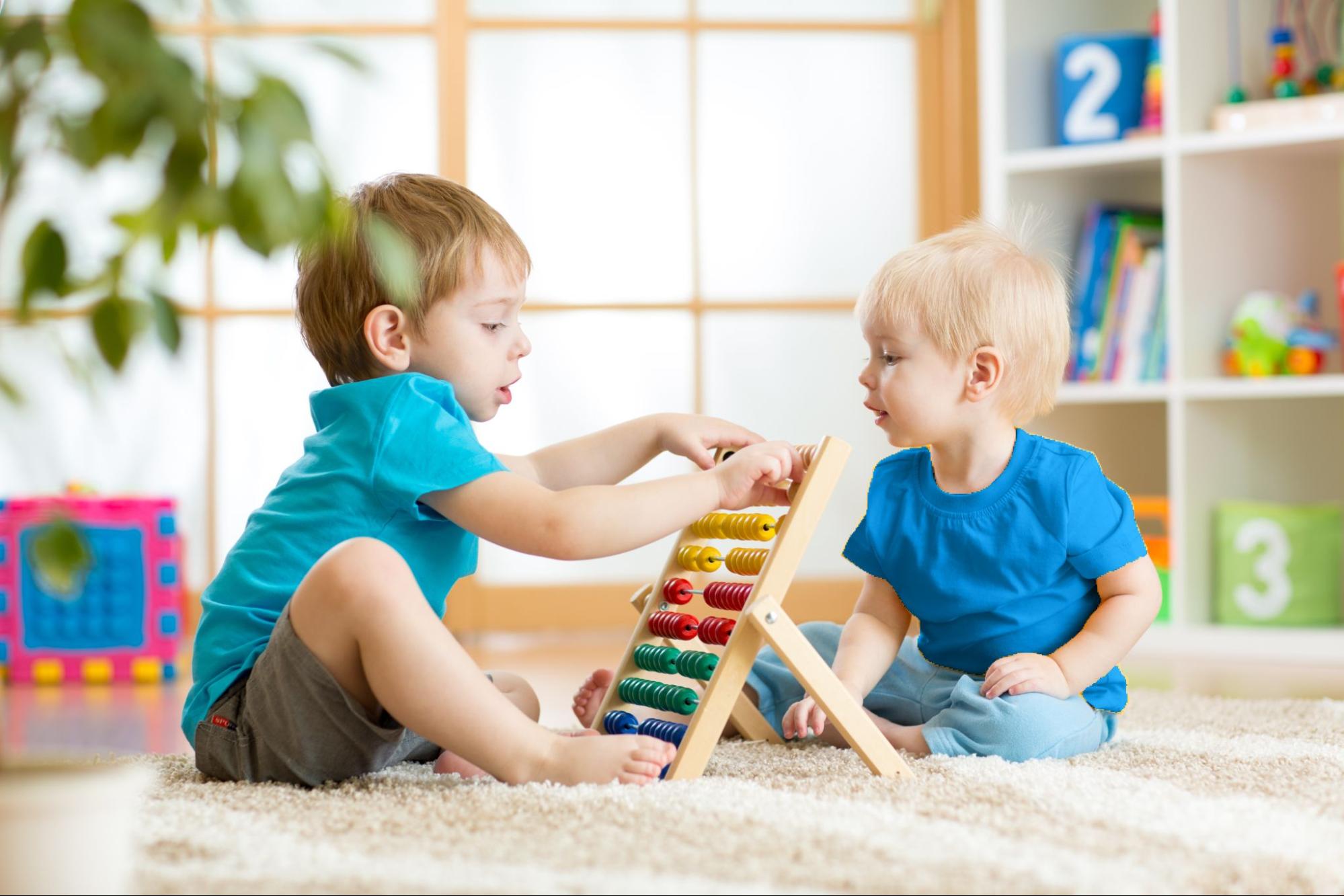 This is an image of two young boys playing with an abacus.