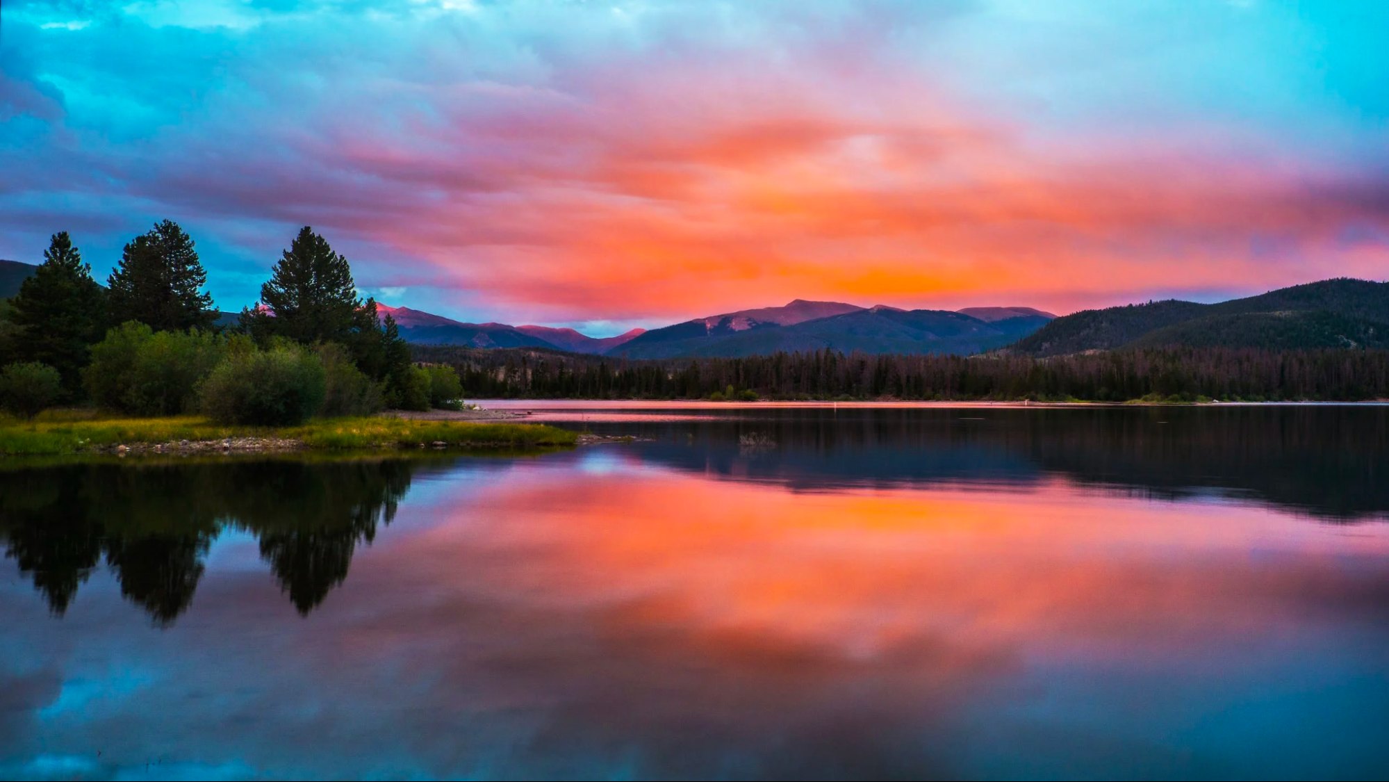 This is an image of a Colorado lake at sunset, with mountains in the background.