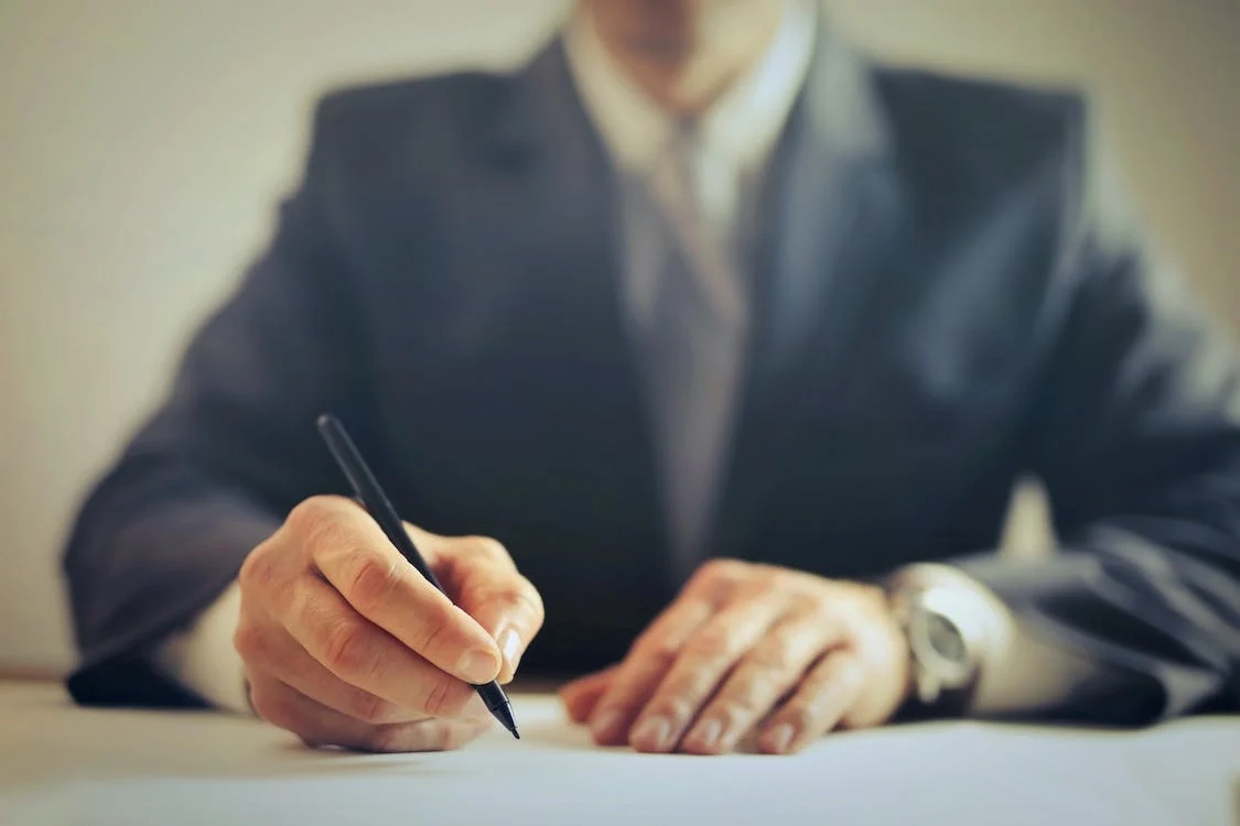 This is an image of a person signing papers.
