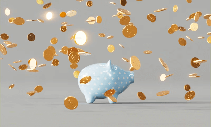 Image of a piggy bank with gold coins falling