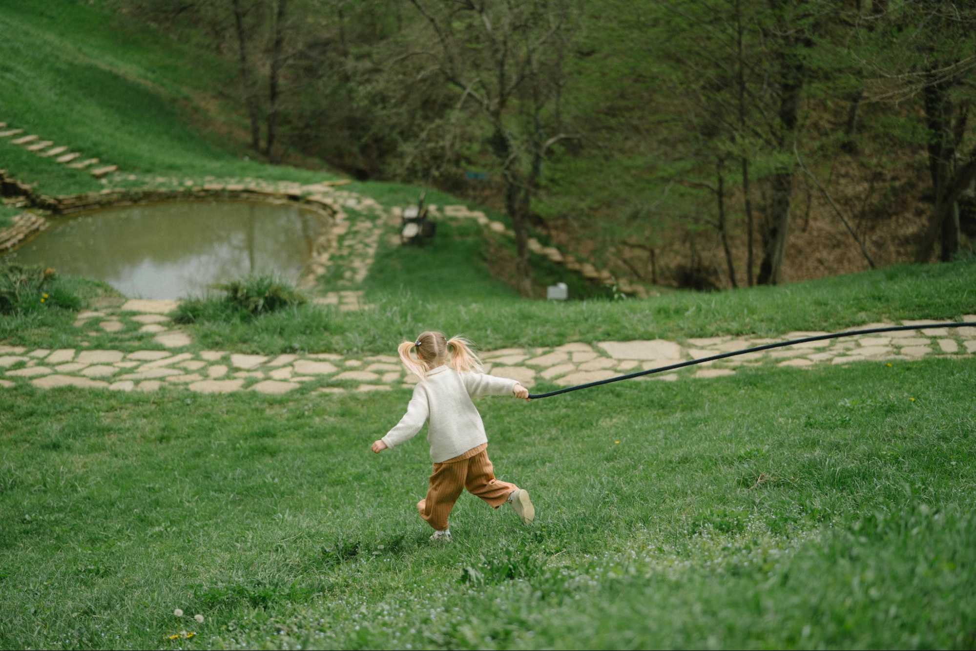 This is an image of a small child running in the grass.