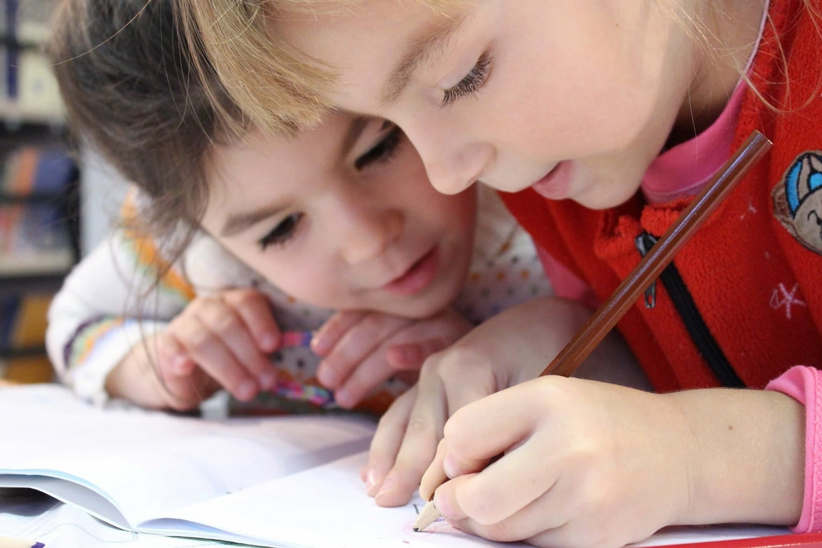 This is an image of two sisters drawing together.