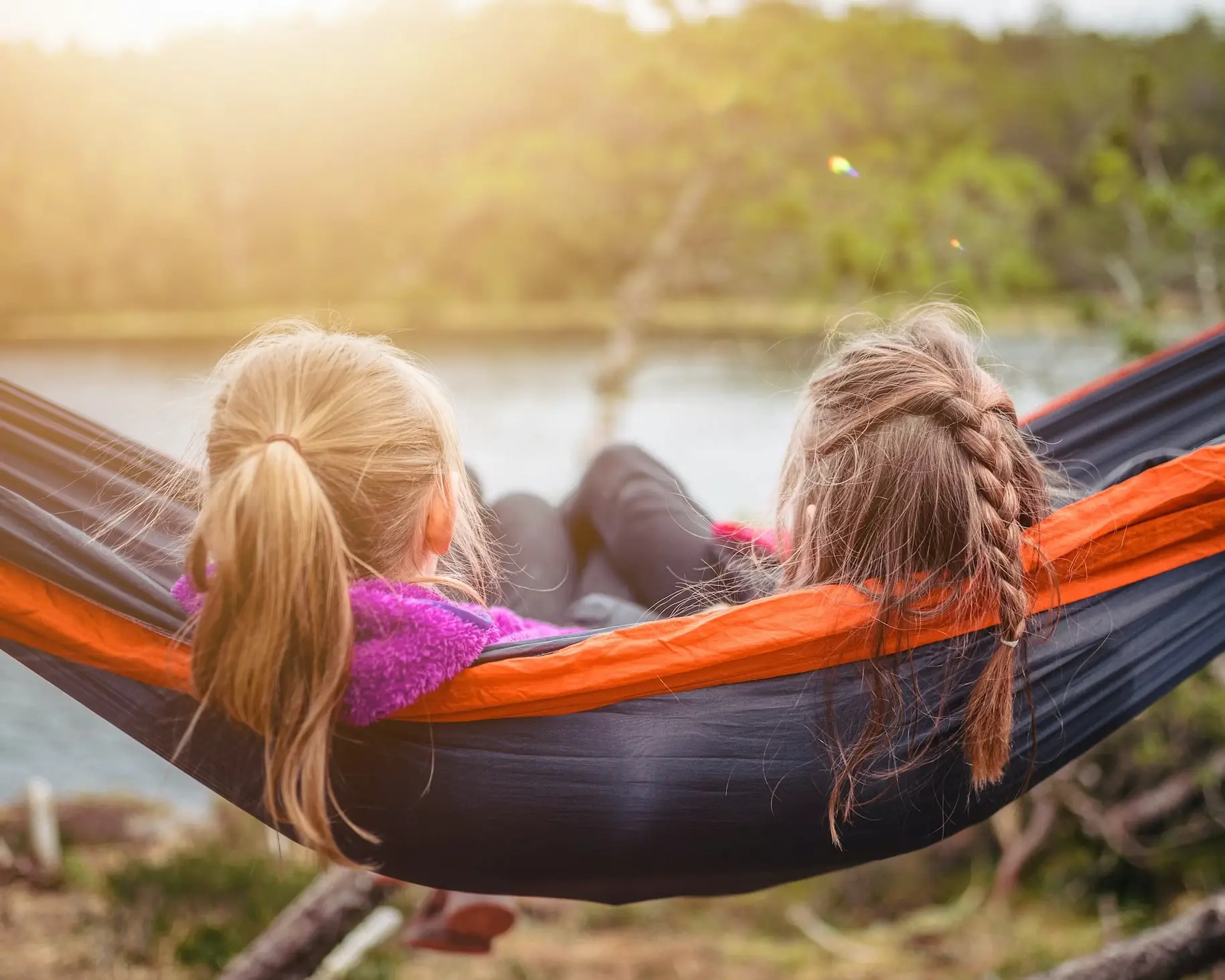 This is an image of two sisters sitting together in a hammock.
