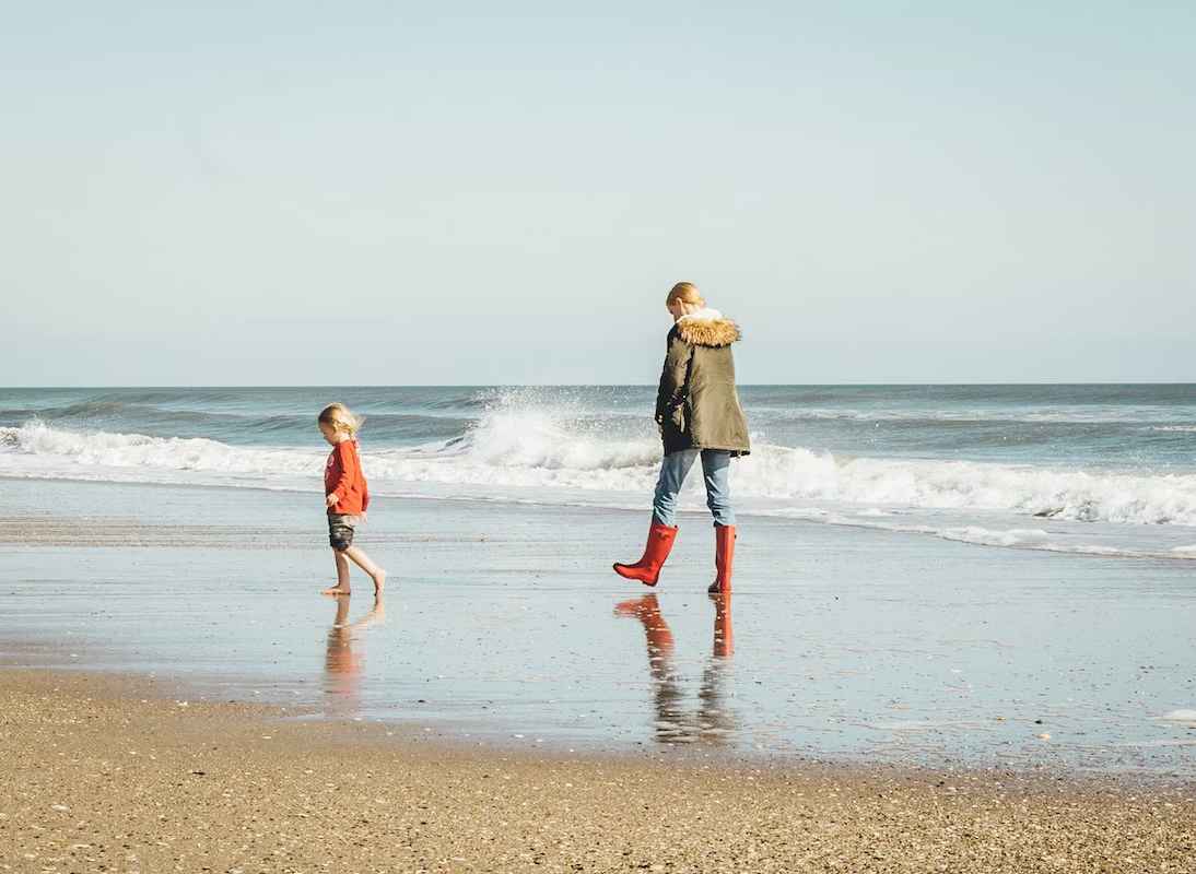 parent and child walking at the beach
