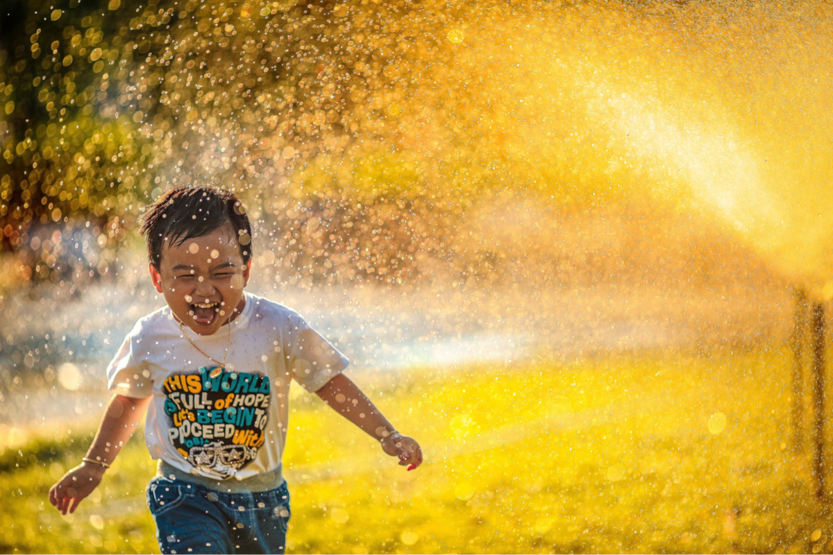 Boy running through water while laughing