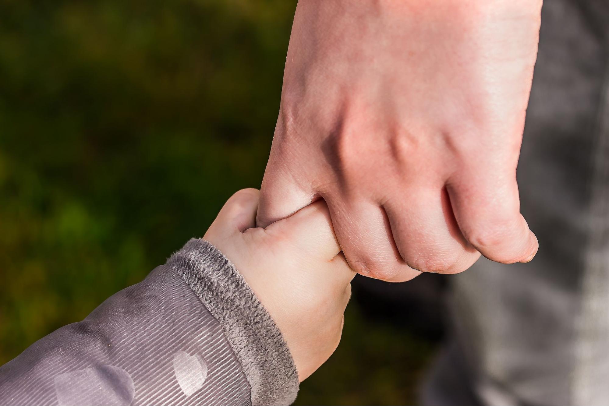 This is an image of a child and parent holding hands.
