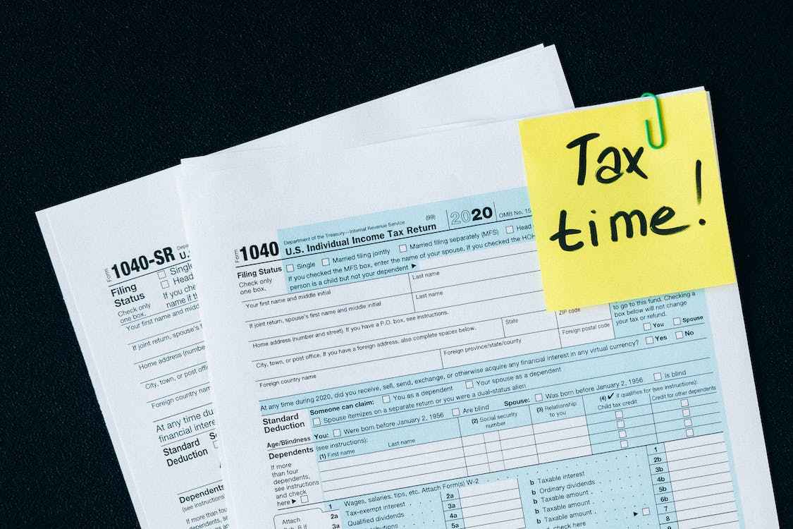 image of tax documents with a sticky note reminder