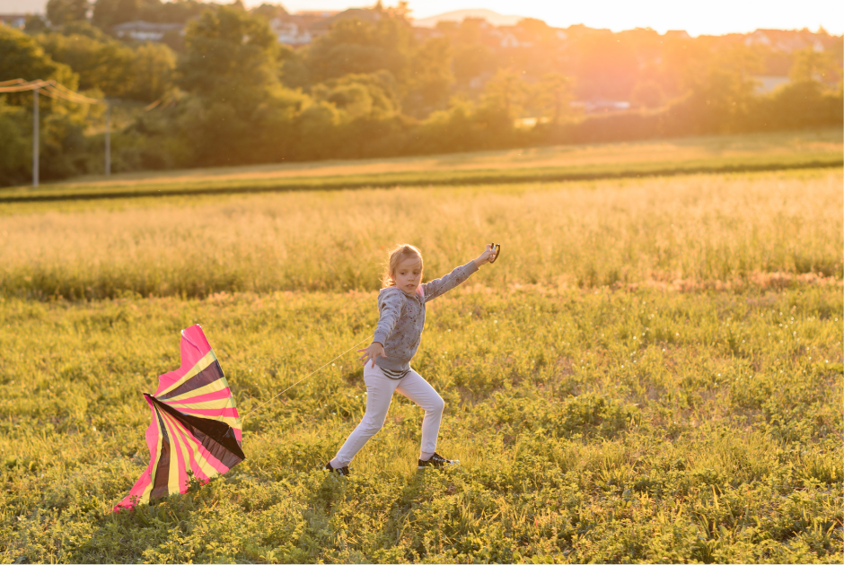 This is an image of a child running in a field with a kite.