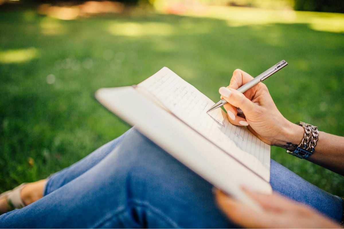 This is an image of a person writing in a journal.