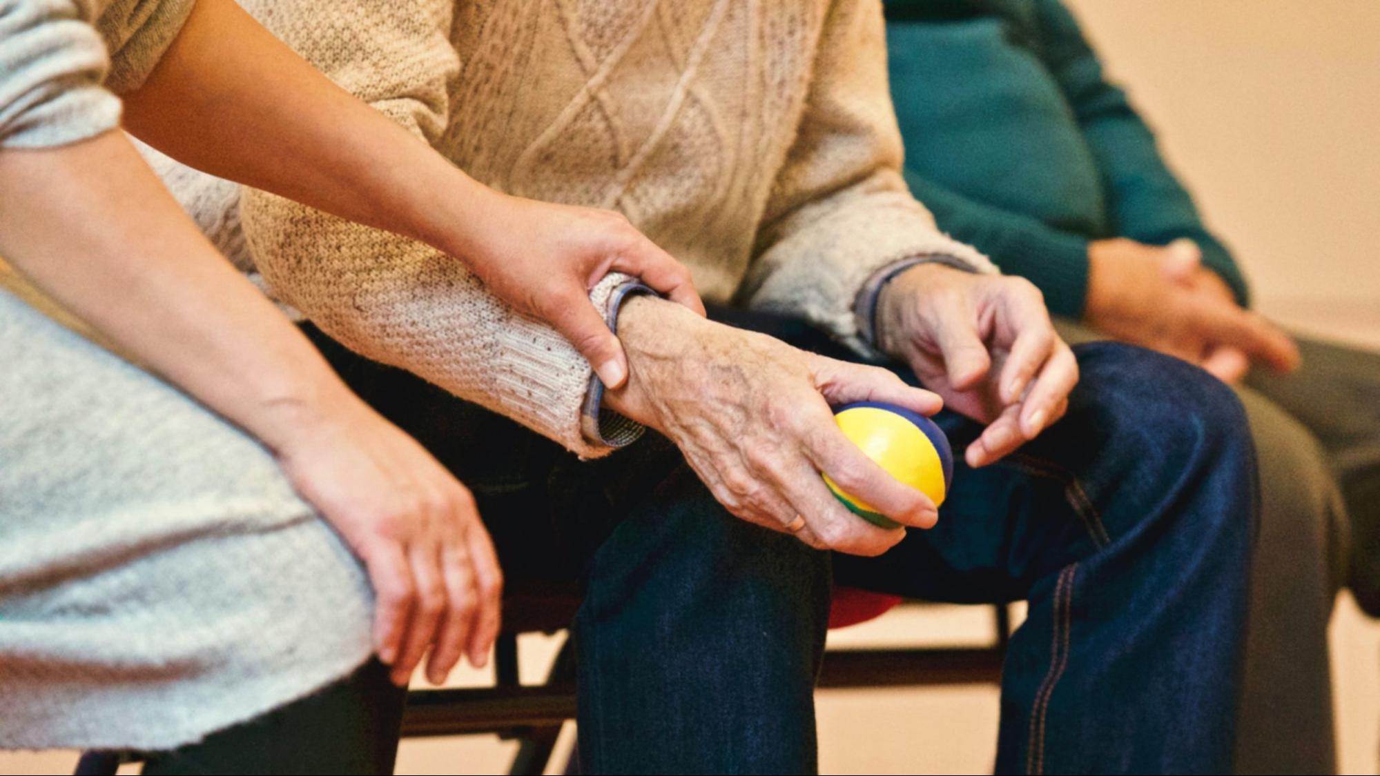 This is an image of an elderly person holding a stress ball.