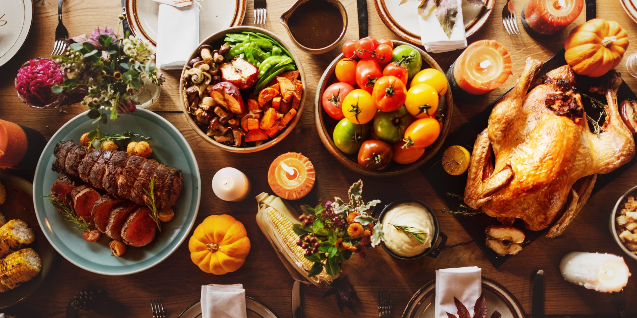 a,festive,thanksgiving,table,with,turkey,,vegetables,,and,candles.,thanksgiving